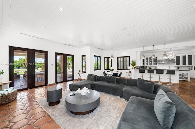 tiled living room with french doors and a healthy amount of sunlight