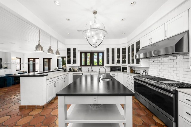 kitchen with stainless steel appliances, hanging light fixtures, a center island with sink, and sink