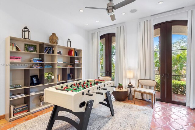 recreation room with tile patterned floors, ceiling fan, and french doors