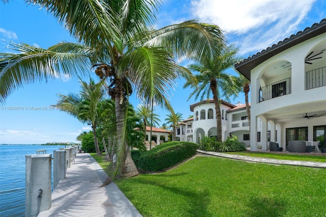 view of home's community featuring a lawn and a water view