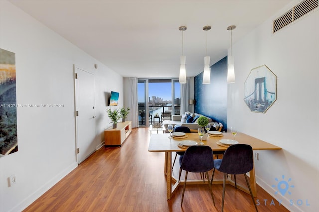 dining space featuring wood-type flooring and expansive windows