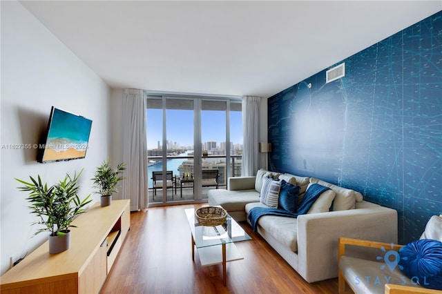 living room featuring a wall of windows and hardwood / wood-style floors