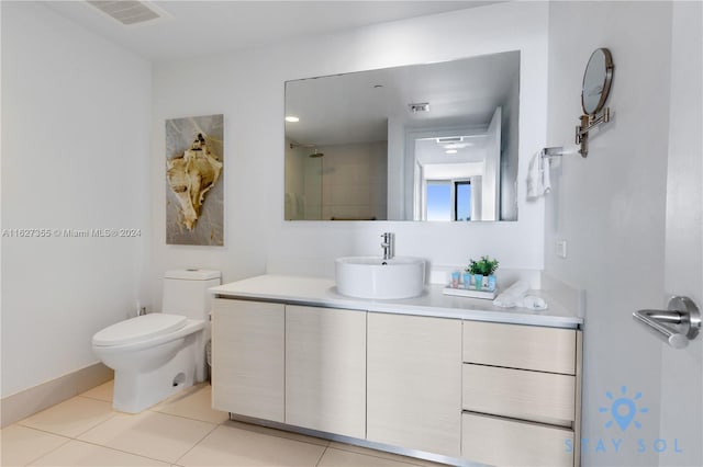 bathroom featuring vanity, tile patterned flooring, and toilet