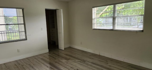 empty room with wood-type flooring and a wealth of natural light