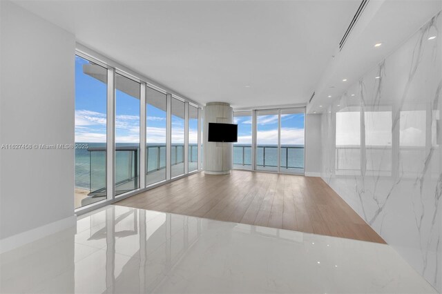 empty room featuring light hardwood / wood-style flooring and a wall of windows