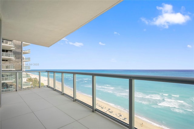 balcony featuring a beach view and a water view