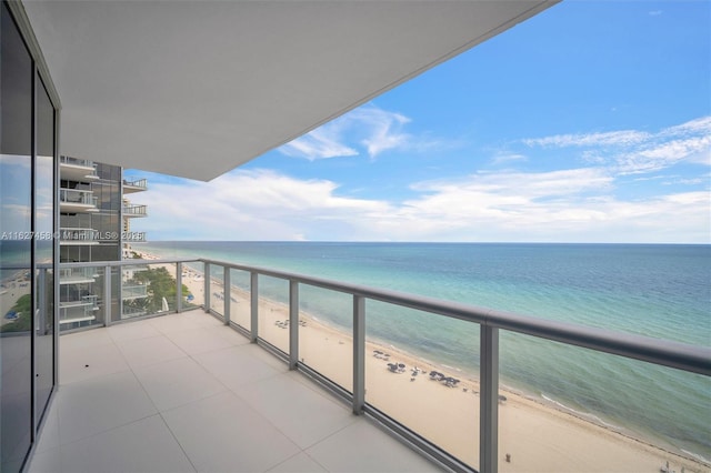 balcony featuring a view of the beach and a water view