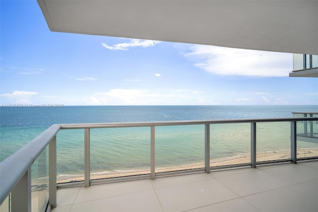 balcony featuring a water view and a view of the beach