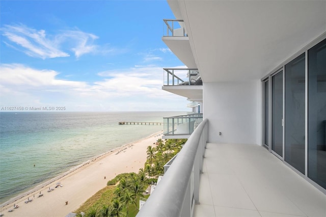 balcony with a water view and a beach view