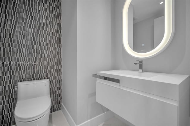 bathroom featuring vanity, tile walls, and toilet