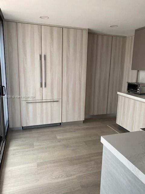 kitchen with light hardwood / wood-style floors and light brown cabinets