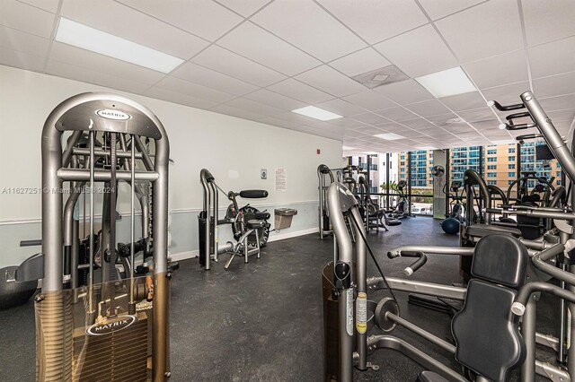 exercise room with expansive windows and a paneled ceiling