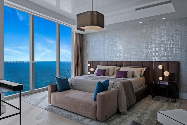 bedroom with a water view and floor to ceiling windows