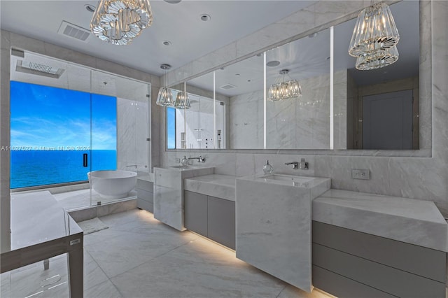 bathroom with tile walls, a washtub, a water view, tile patterned floors, and vanity