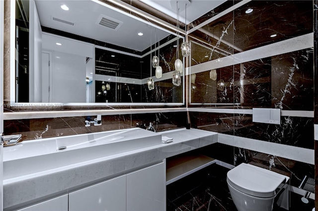 bathroom featuring vanity, tile walls, toilet, and tile patterned flooring