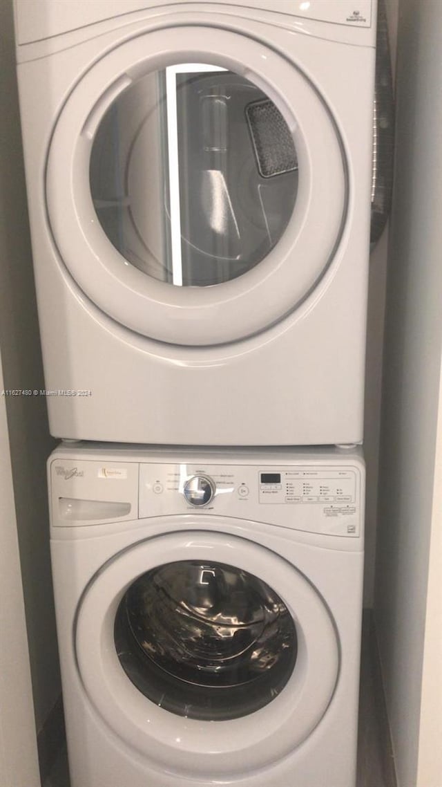 clothes washing area featuring stacked washing maching and dryer