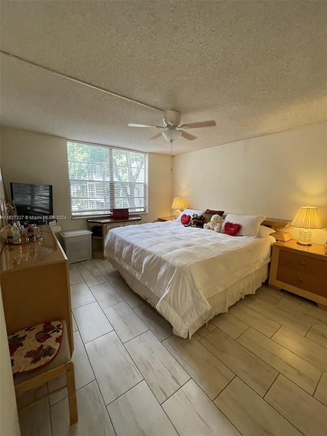 bedroom featuring ceiling fan and a textured ceiling