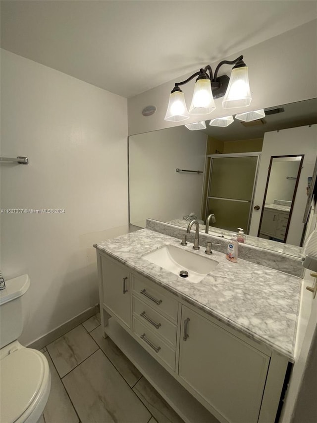 bathroom with vanity, an enclosed shower, and toilet