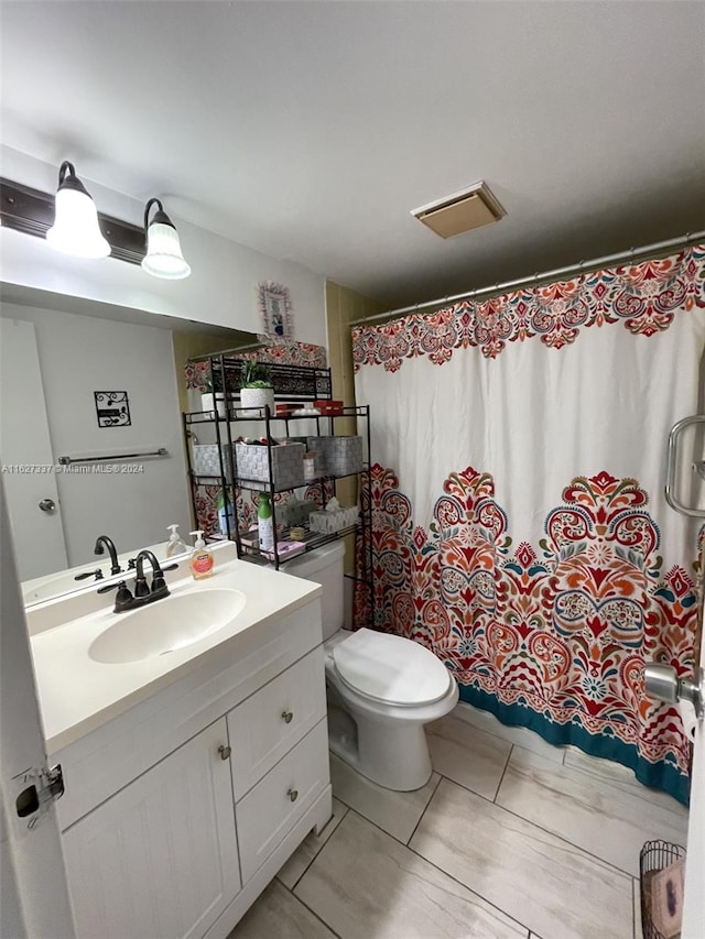 bathroom featuring tile patterned flooring, vanity, and toilet