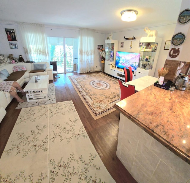 living room with dark hardwood / wood-style flooring and ornamental molding