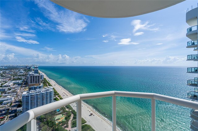 balcony with a water view and a beach view