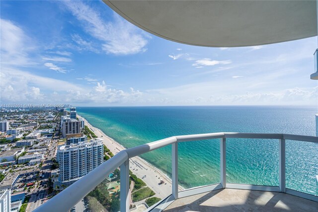 balcony with a water view and a beach view