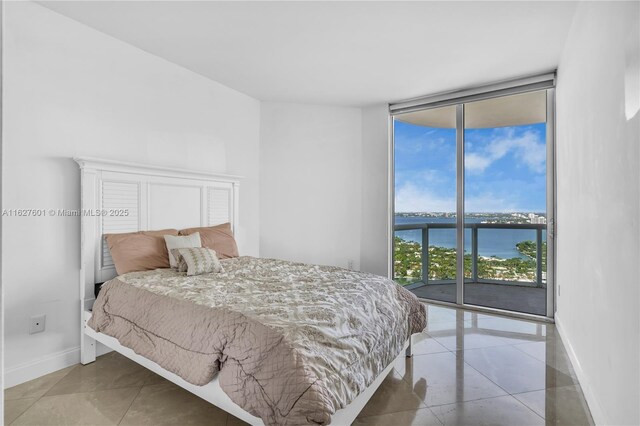 bedroom with a water view, floor to ceiling windows, and access to exterior