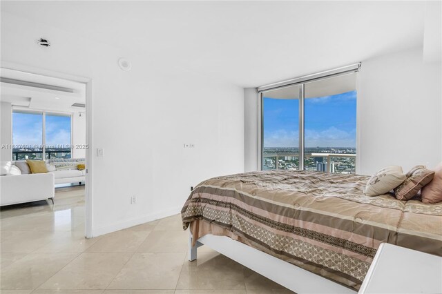 bedroom featuring expansive windows and access to outside