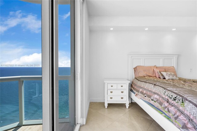 bedroom featuring a water view and light tile patterned floors