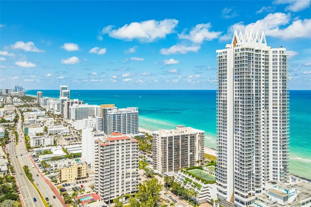 birds eye view of property with a water view and a beach view