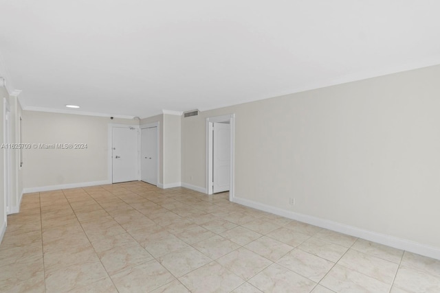 spare room featuring light tile patterned floors and ornamental molding