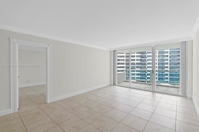 empty room featuring light tile patterned floors, ornamental molding, and floor to ceiling windows