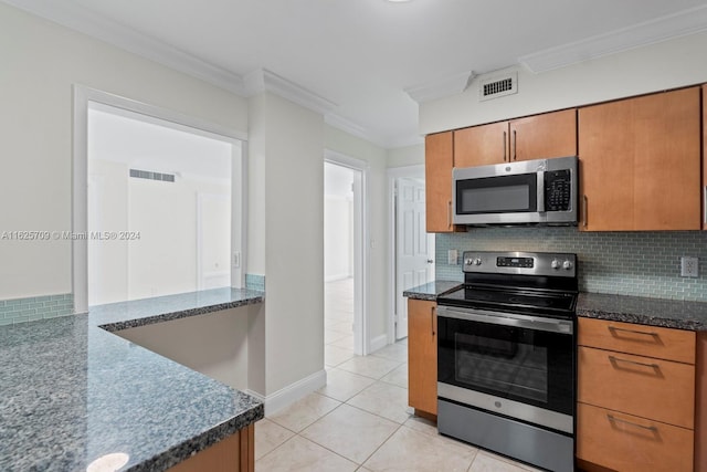 kitchen featuring light tile patterned floors, decorative backsplash, crown molding, and stainless steel appliances