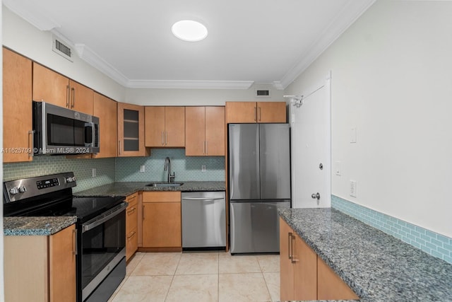 kitchen with appliances with stainless steel finishes, decorative backsplash, light tile patterned flooring, ornamental molding, and sink