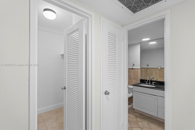 bathroom with vanity, ornamental molding, and tasteful backsplash