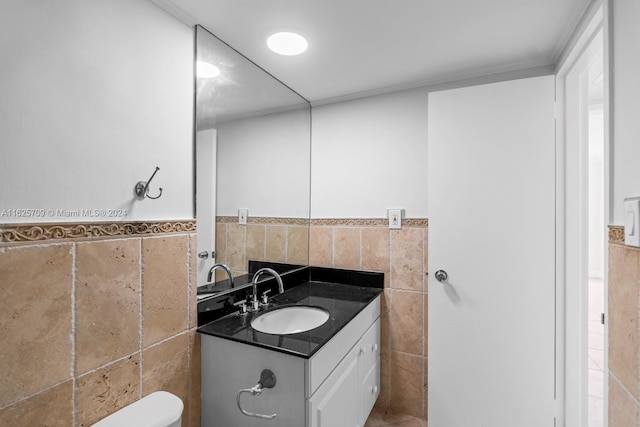 bathroom featuring tile walls, toilet, and vanity