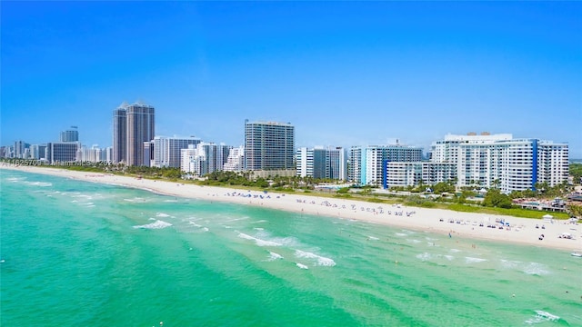 birds eye view of property featuring a water view and a beach view