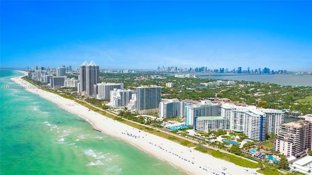 birds eye view of property with a water view and a beach view