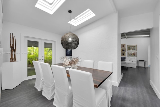 dining area featuring dark wood-type flooring, french doors, and vaulted ceiling with skylight