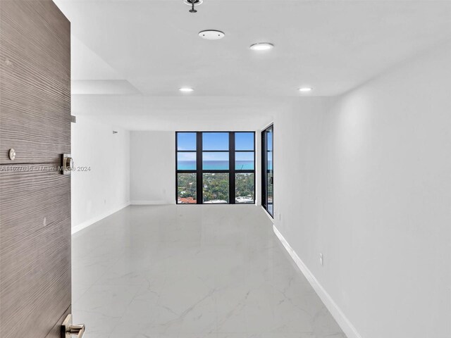 spare room with expansive windows and tile patterned floors