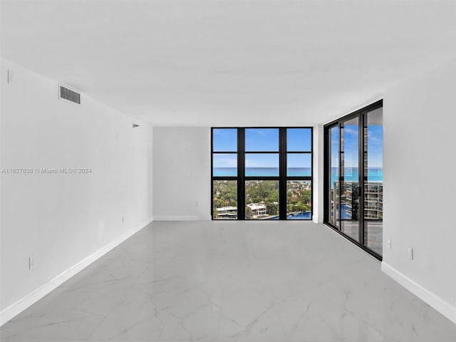 empty room with floor to ceiling windows and a water view