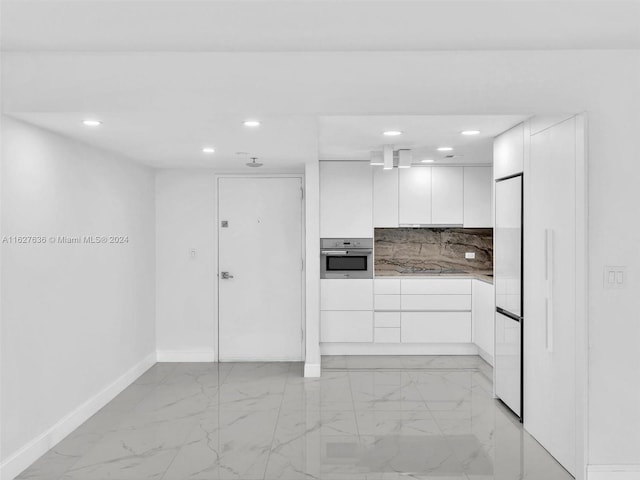 kitchen featuring built in fridge, oven, white cabinets, backsplash, and black electric cooktop