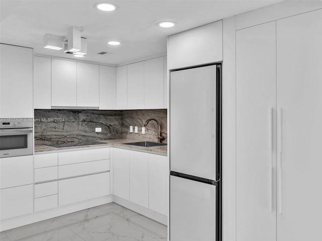 kitchen with sink, refrigerator, black electric stovetop, oven, and white cabinets