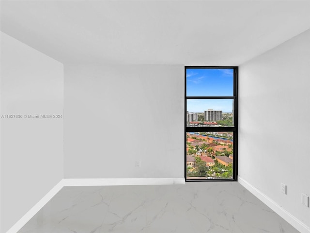 spare room with floor to ceiling windows and plenty of natural light