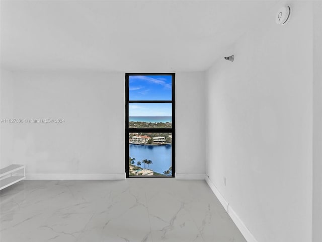 empty room with a wall of windows and a water view