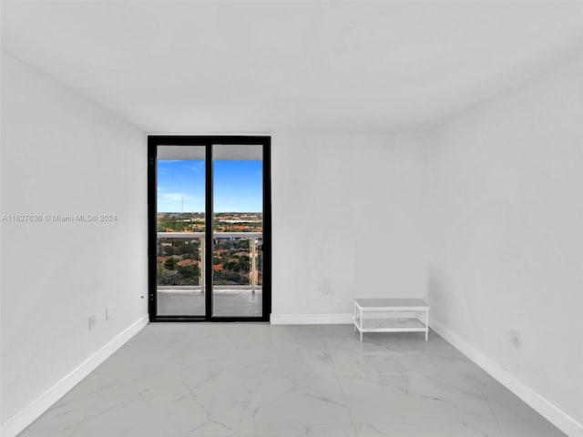 unfurnished room with a wall of windows