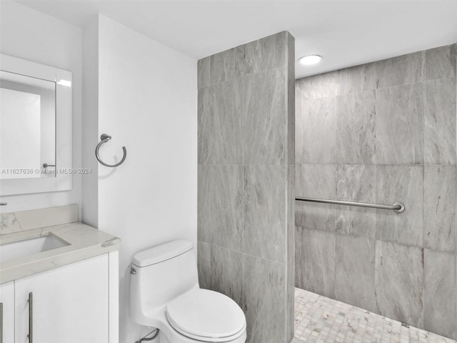 bathroom featuring vanity, toilet, and tiled shower