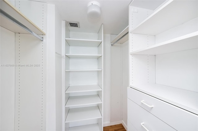 walk in closet with hardwood / wood-style floors