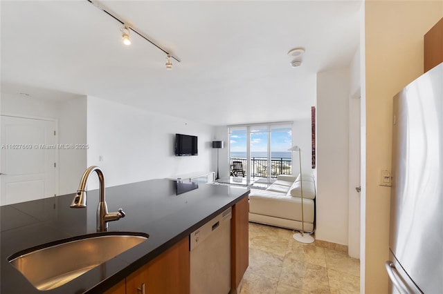 kitchen with dishwasher, stainless steel fridge, a wall of windows, and sink