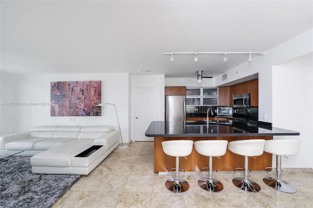 kitchen featuring sink, appliances with stainless steel finishes, tasteful backsplash, a kitchen bar, and kitchen peninsula